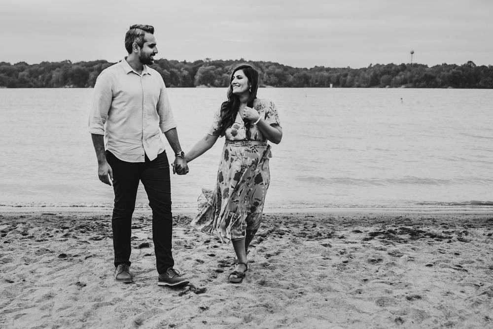 husband holds wife hand as they celebrate their new baby to be
