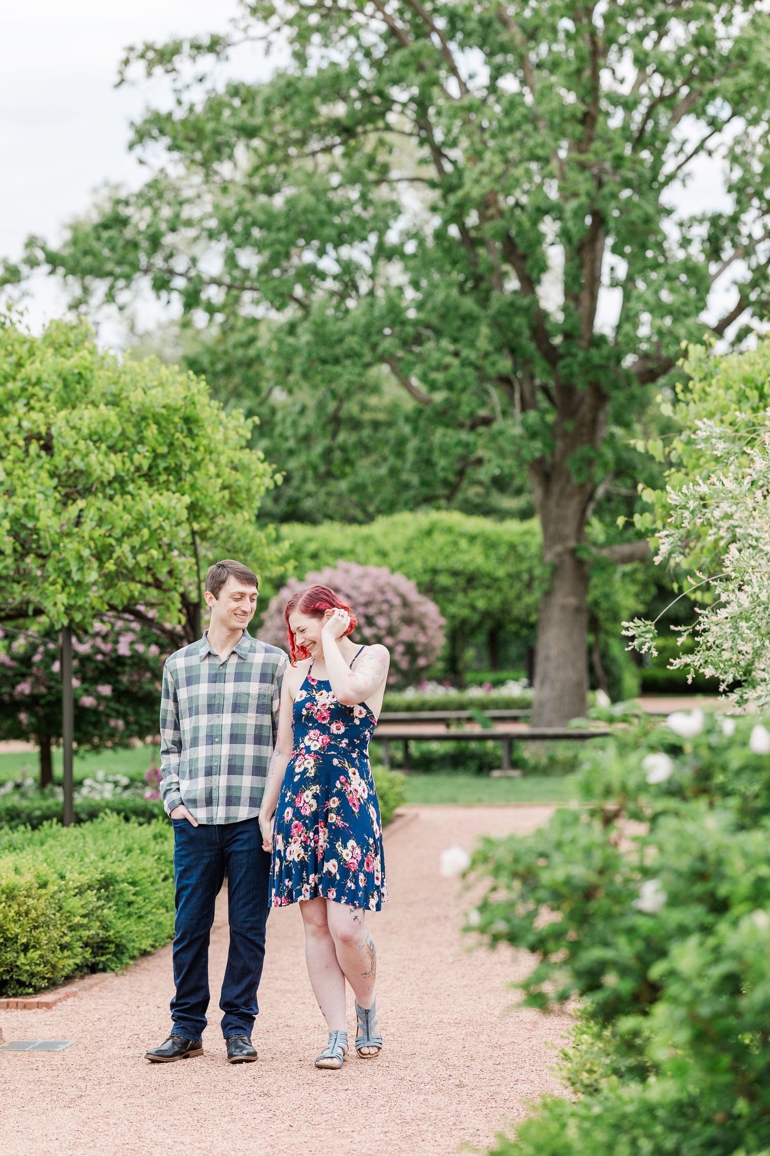 Close-up black and white photo showing hands with a butterfly tattoo resting on a floral print dress at Cantigny Park