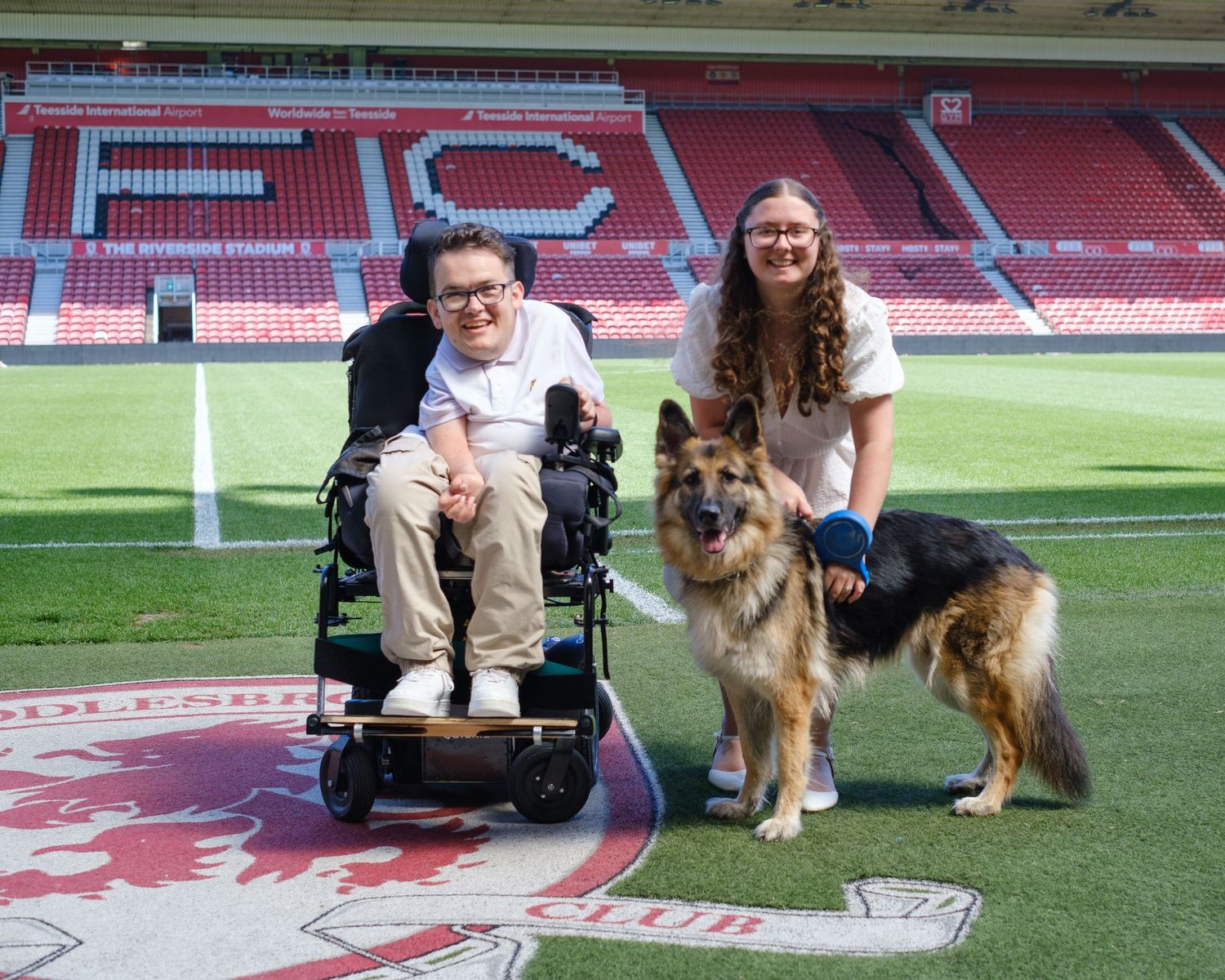 Lucy and Owen with their dog Roxy, at the side of the pitch having their pre-wedding shoot.