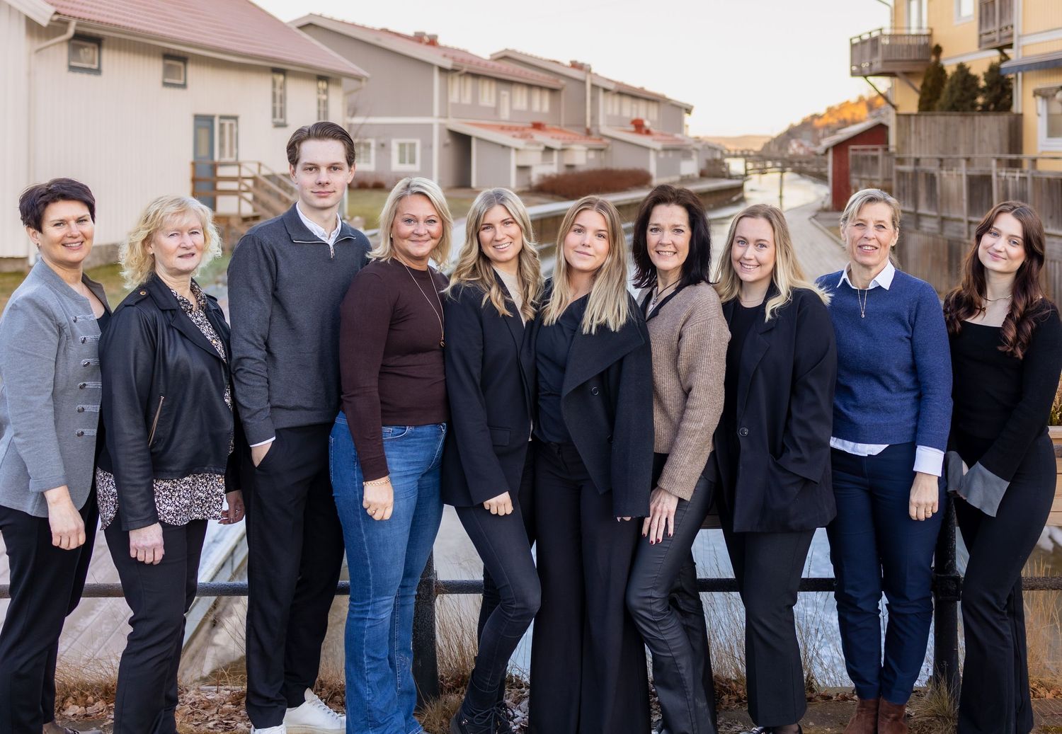 A group of professionals standing together outdoors in casual business attire against an urban backdrop.