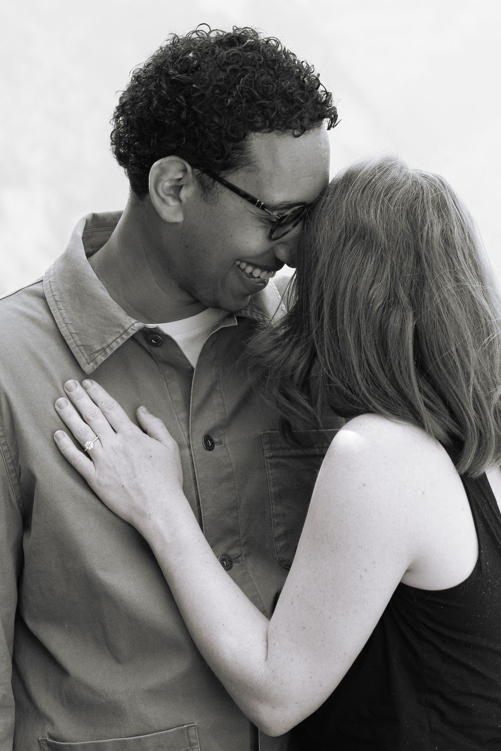 A black and white intimate portrait of a couple sharing a tender romantic moment together.