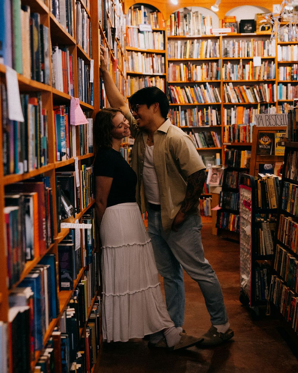 A couple laughing in a store while the man flirts with his girlfriend.