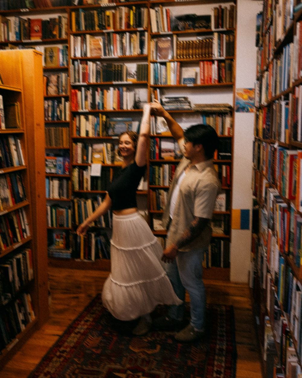 A couple dancing in a bookstore.