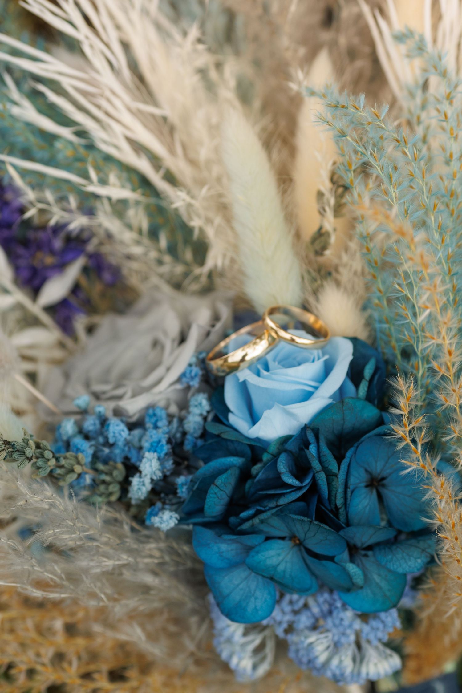 Close up of blue and white wedding flowers with delicate dried elements in a soft natural arrangement.