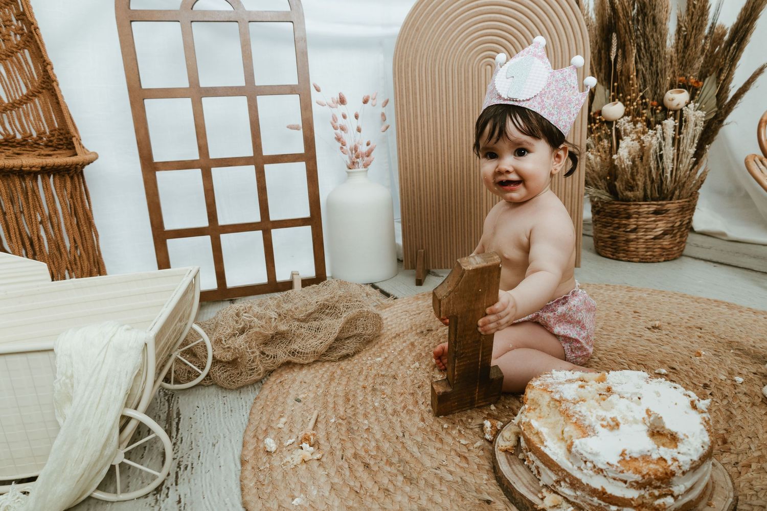Niña de un año riendo y disfrutando con su tarta en su sesión Smash Cake en Valencia