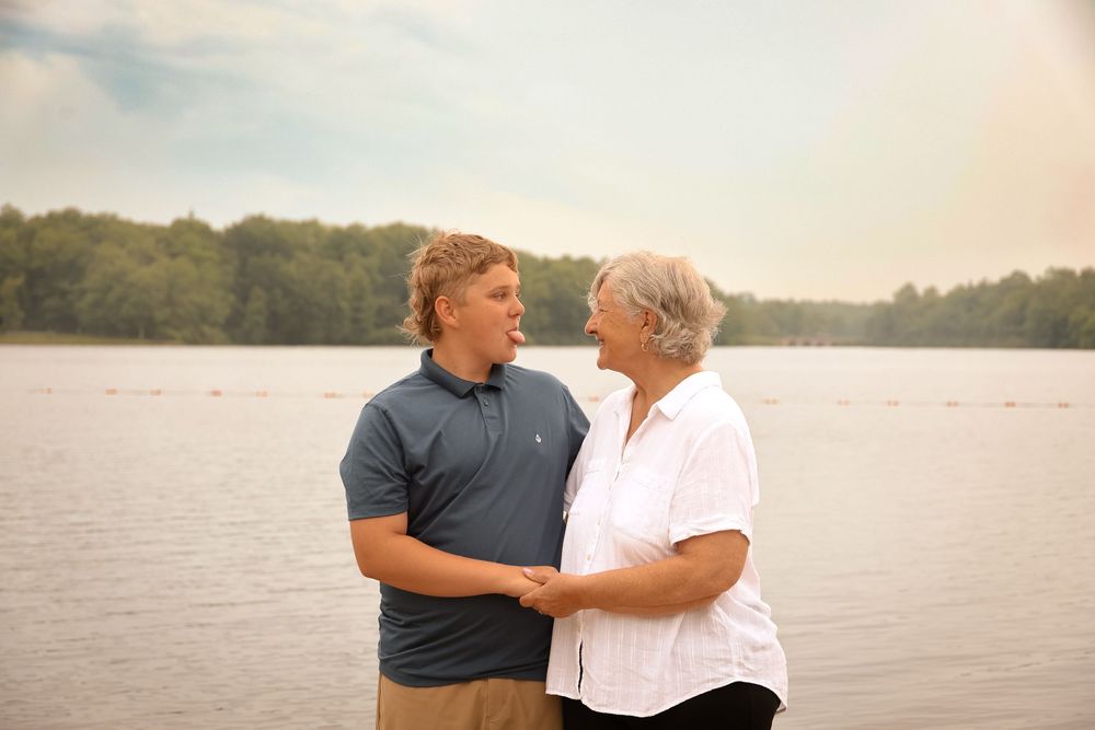 A couple shares an intimate moment standing by a serene lake at sunset.