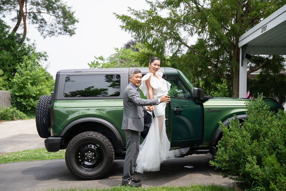 Four wedding photos feature a vintage green Defender vehicle in romantic outdoor settings with lush greenery.