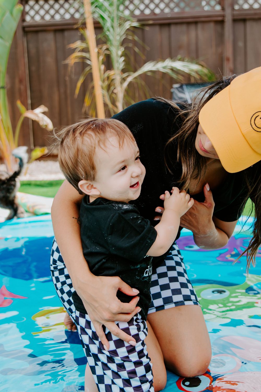 Joyful moment at a summer pool party with checkered swim outfits.
