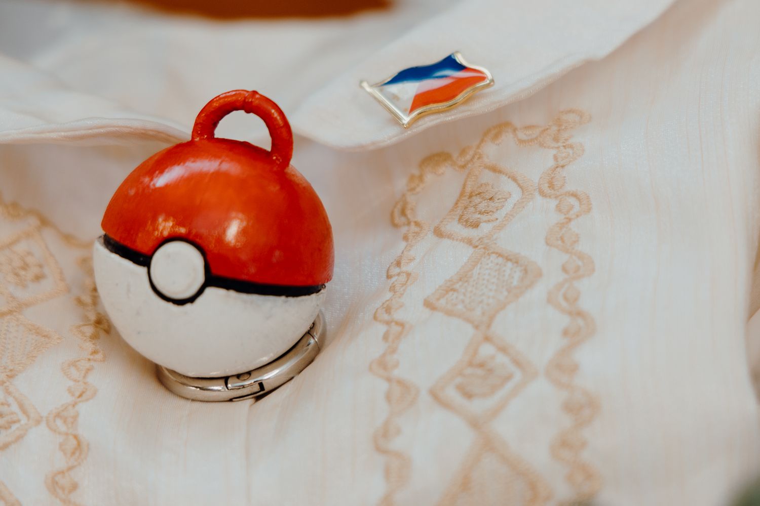 Red and white Pokeball decoration with Filipino flag pin on embroidered fabric.