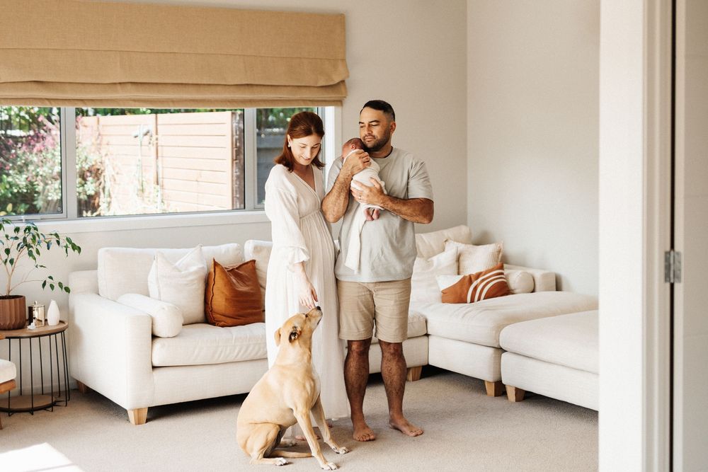 A bright and airy living room interior with a white sofa and window treatments in warm neutral tones.