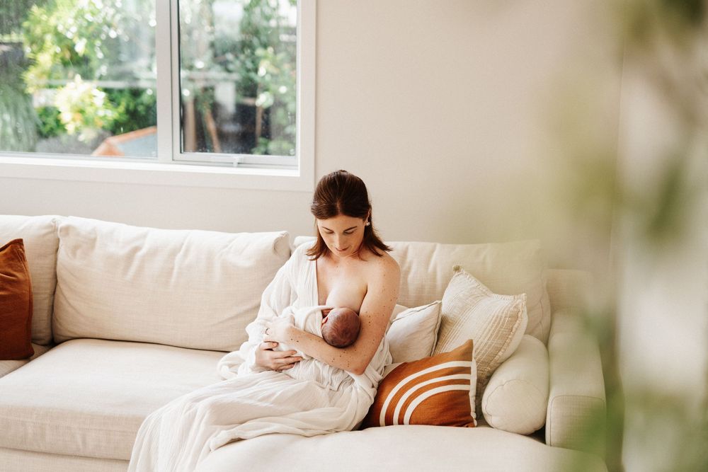 Person relaxes on comfortable white sofa in bright modern living area, enjoying peaceful moment at home.