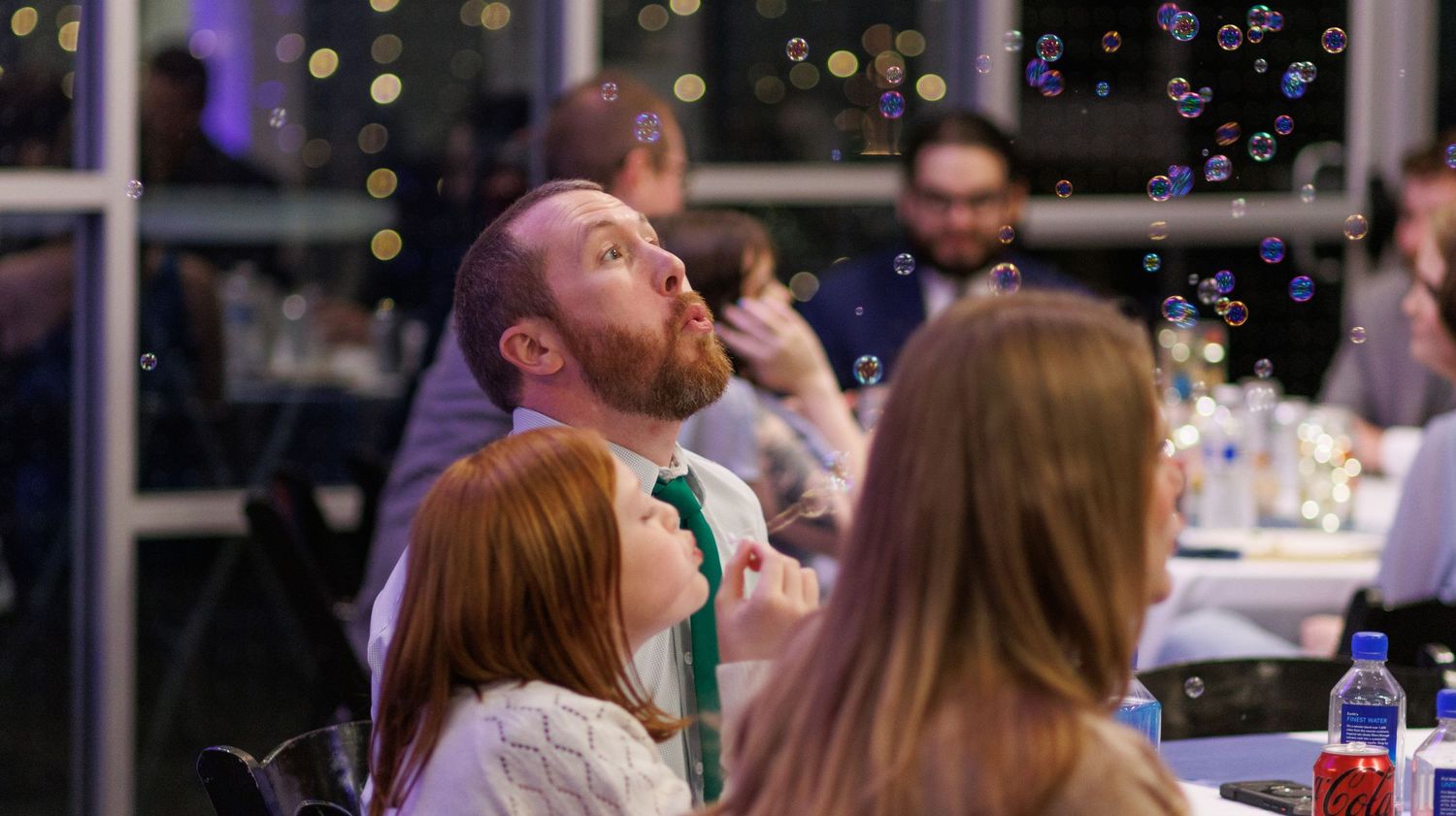 Two people enjoying ice cream together at an elegant indoor venue with floral decor in the background.