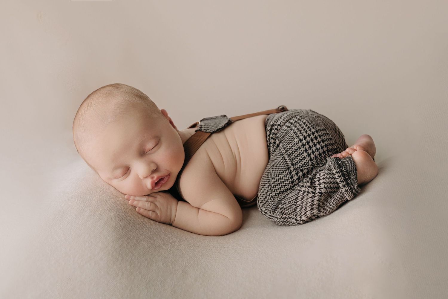 Series of sleeping newborn photos with baby wearing plaid outfit on beige backdrop.