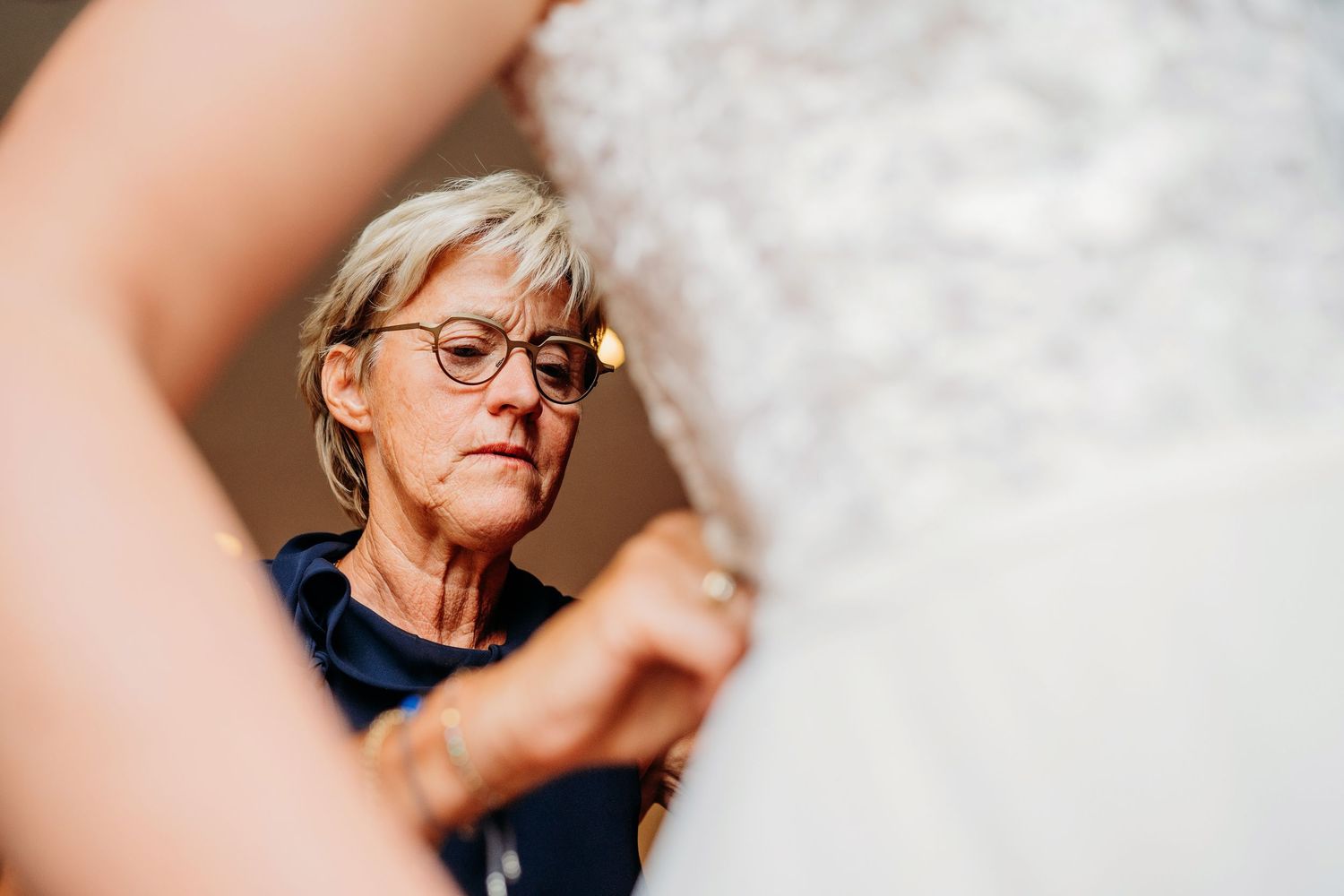 Close-up portraits of someone with blonde hair and stylish glasses in various contemplative poses against a light background.