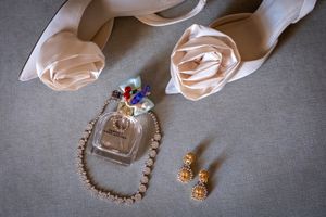 Wedding accessories and jewelry arranged on a gray textured background.