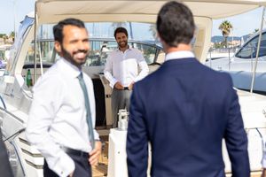 Business gathering aboard a luxury yacht with nautical backdrop.