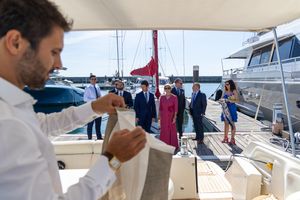 Person pouring drinks during a social event on a yacht deck.