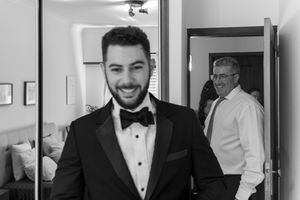 Formal black tie attire preparation in dressing room.