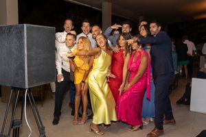 Group of wedding guests posing together at reception photo booth.