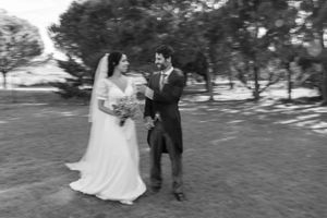 Black and white wedding portrait of couple walking outdoors.