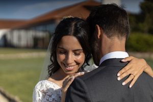 Intimate moment between newlyweds sharing a close embrace outdoors on their wedding day.