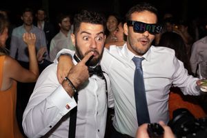 Wedding guests having fun and making silly faces at a reception party.