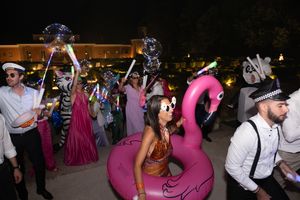 Wedding reception party with guests dancing and pink flamingo pool float.