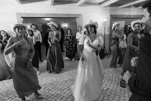 Black and white photo of wedding guests dancing at indoor reception.