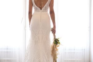 Close-up details of a backless lace wedding gown with intricate design elements.