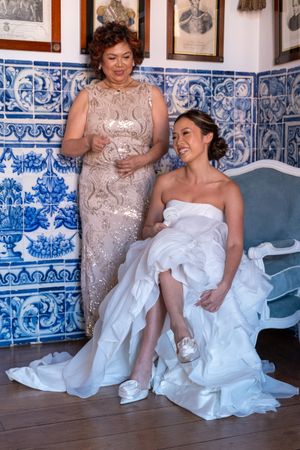 Wedding preparations in a room with blue and white Portuguese tile walls and ornate decor.