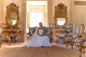 Panoramic view of a grand baroque room with ornate mirrors and chairs.