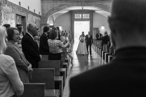 Black and white photos showing guests mingling at an indoor wedding reception.