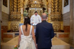 Wedding ceremony in an ornate golden church altar with baroque architectural details.
