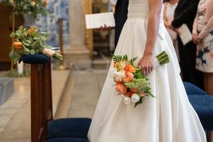 Wedding details showing orange and white floral bouquet arrangements.
