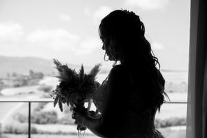 Silhouettes of wedding party members against a bright window backdrop.