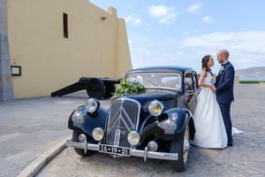 Classic vintage black car featured in outdoor wedding photos.