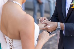 A wedding reception celebration with guests tossing confetti in an outdoor courtyard.