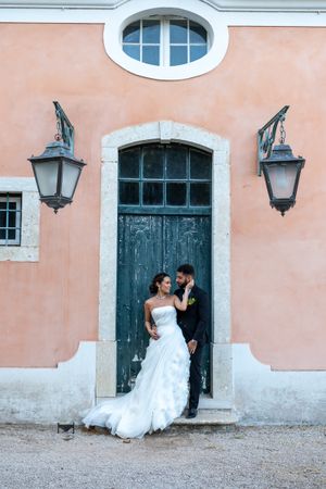 Romantic wedding portraits against pink walls and vintage blue doors.