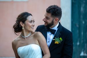 Elegant wedding portraits against a pink and blue architectural backdrop.
