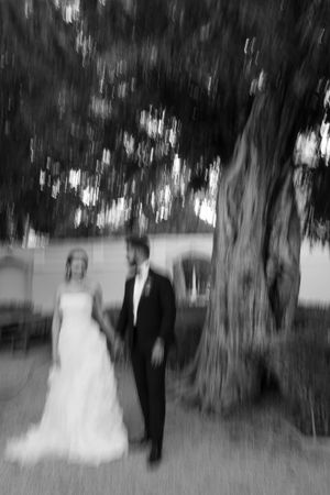 Artistic black and white motion blur wedding portrait under trees.