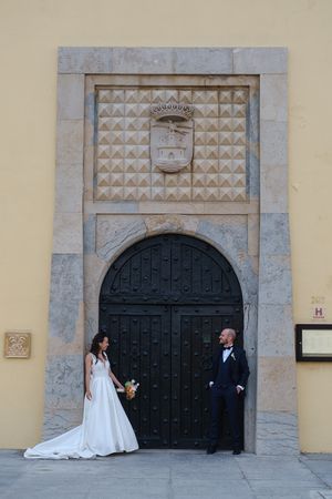 A series of wedding photos showing a couple posing in front of large ornate black doors.