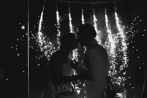 Silhouetted couple against sparkling wedding sparklers creating a magical nighttime atmosphere.