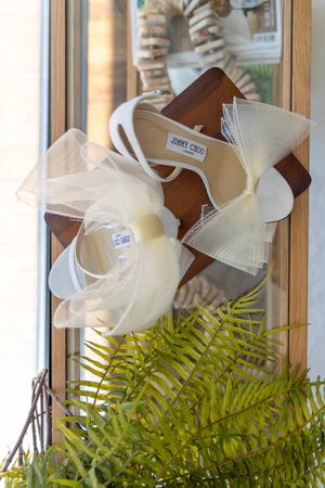 White decorative bow details with green ferns in window light.