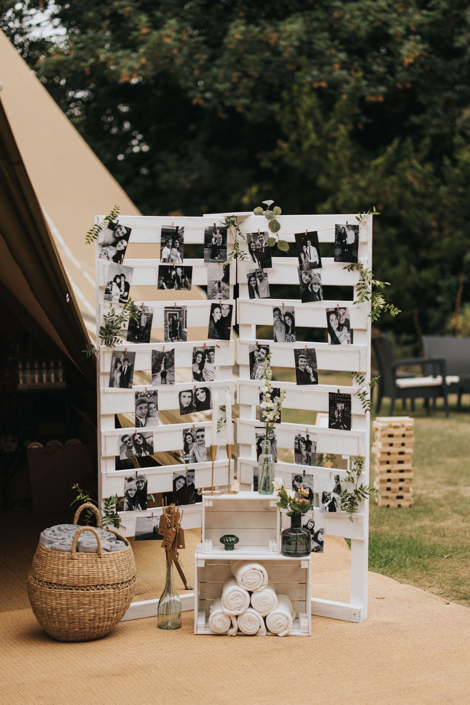 Black and white photo display arrangement decorated with greenery at a rustic outdoor wedding celebration at Hirst Priory.