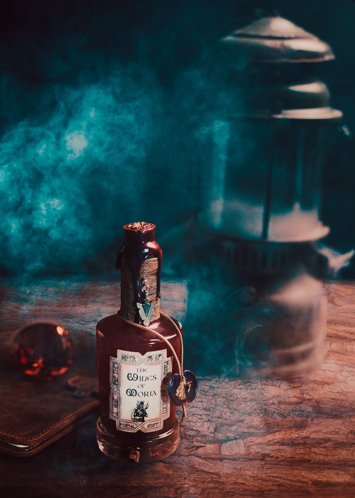 A bottle of spirits on a wooden surface surrounded by mystical turquoise smoke and moody lighting.