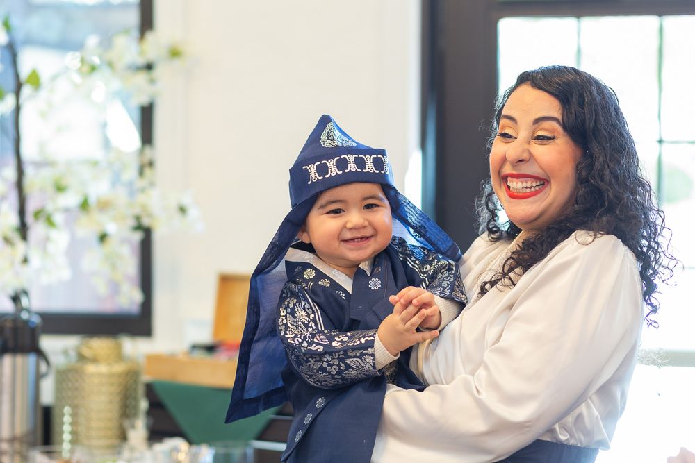 A joyful moment shared between a parent and child wearing a star-patterned winter hat in a bright room.