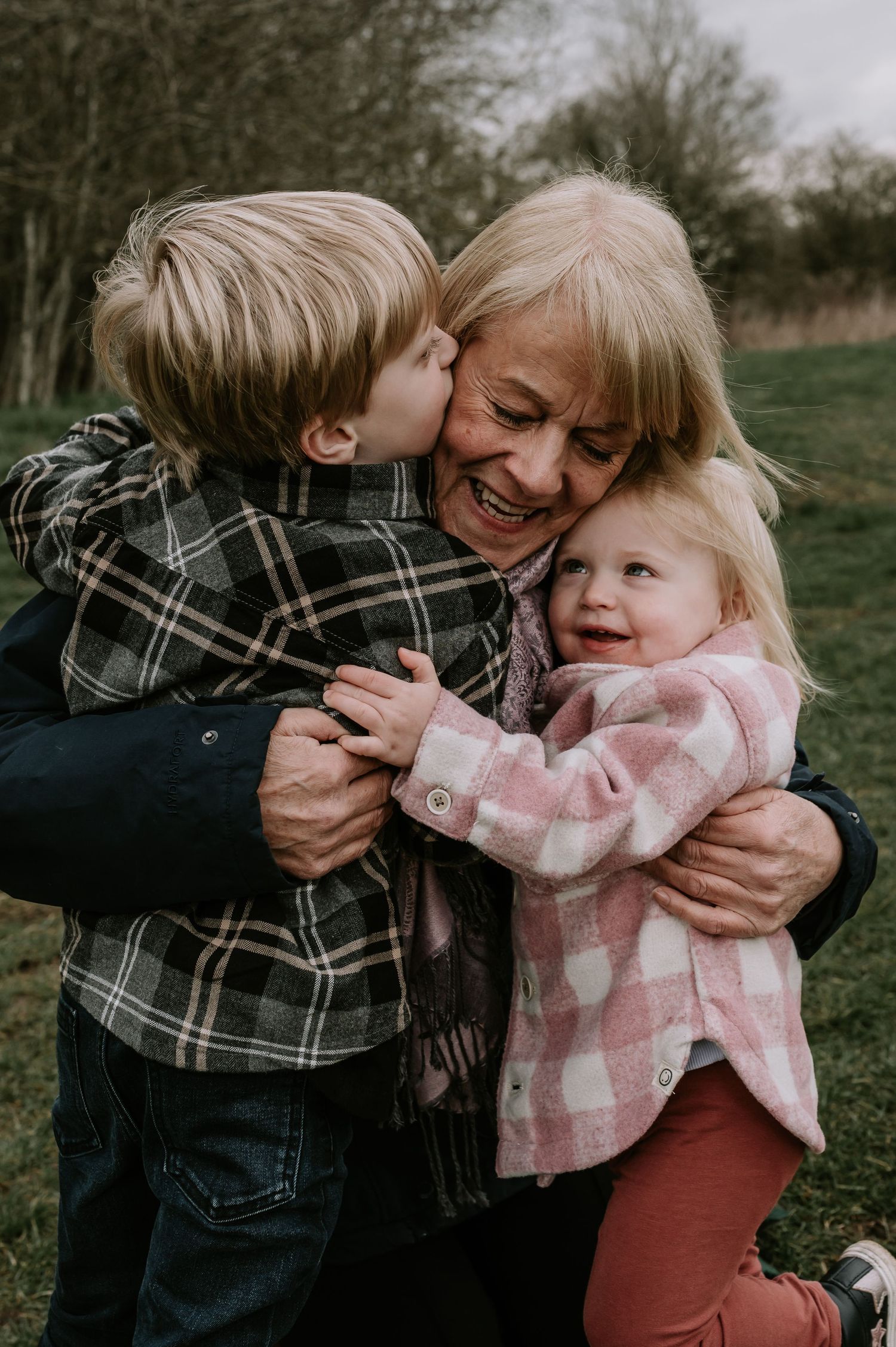 A heartwarming family moment captured outdoors with embraces and laughter on a fall day.