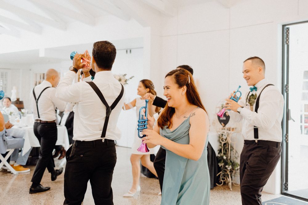 Wedding guests in suspenders and formal attire dance and celebrate captured by Apertured Media Auckland Wedding Photographer.