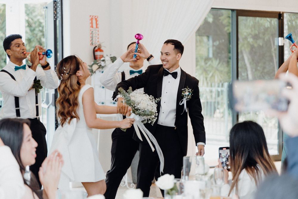 A celebratory toast at an elegant wedding reception captured by Apertured Media Auckland Wedding Photographer.