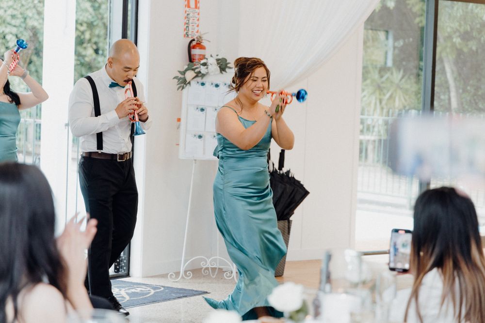 Wedding guests dancing and celebrating with party noisemakers captured by Apertured Media Auckland Wedding Photographer.
